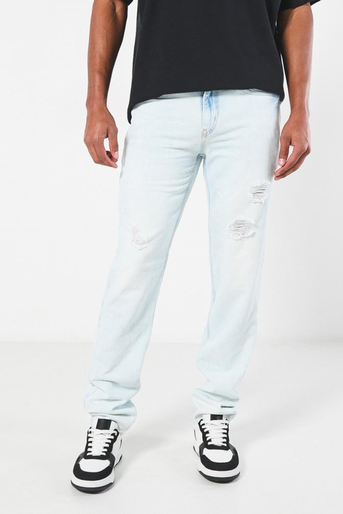 Jean azul claro slim con desgastes, rotos y tiro bajo